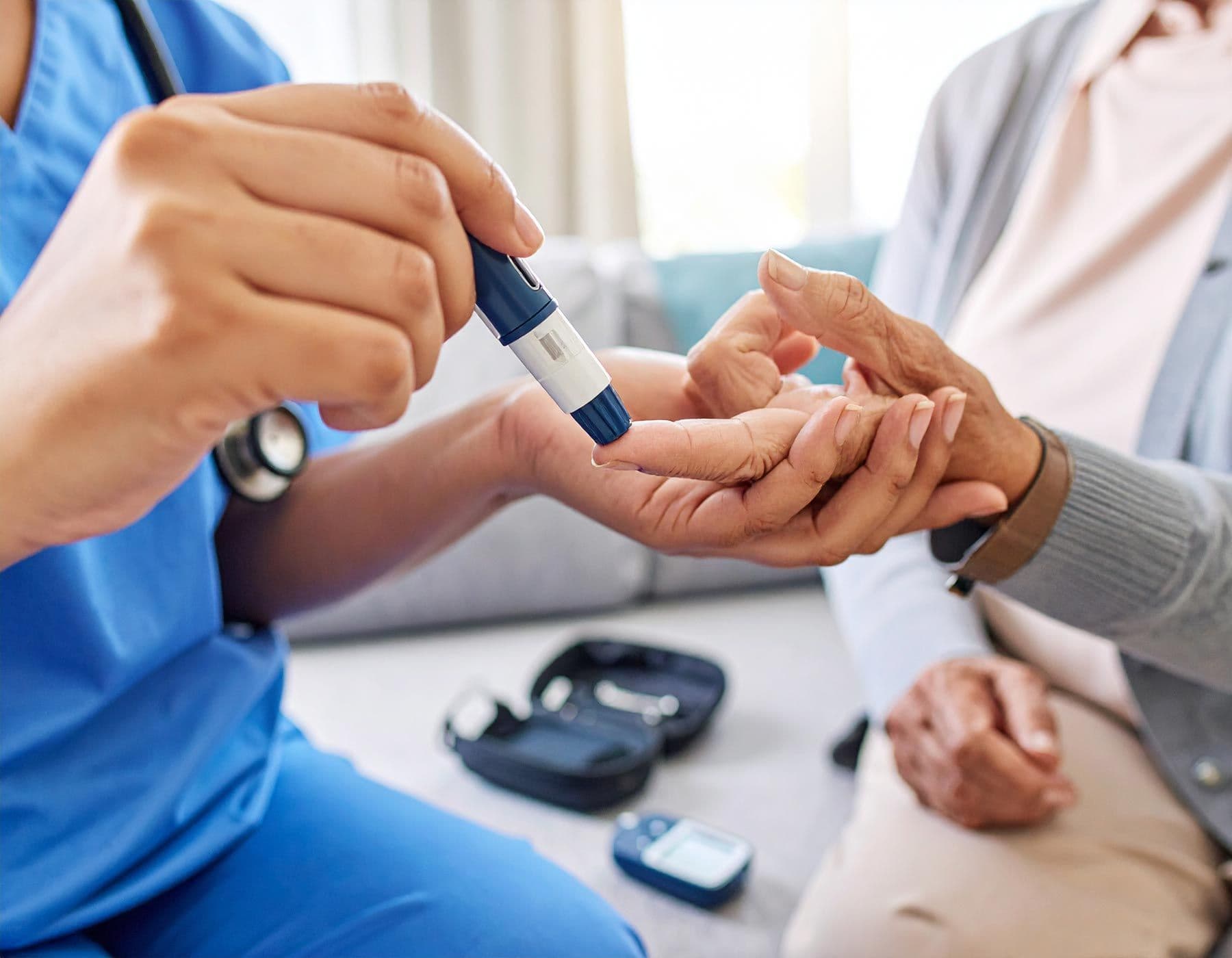 Krankenschwester misst Blutzucker einer Seniorin am Finger