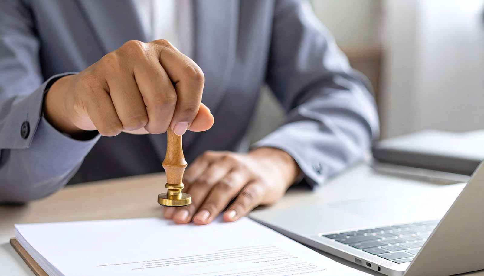 Person stempelt ein Dokument auf einem Schreibtisch