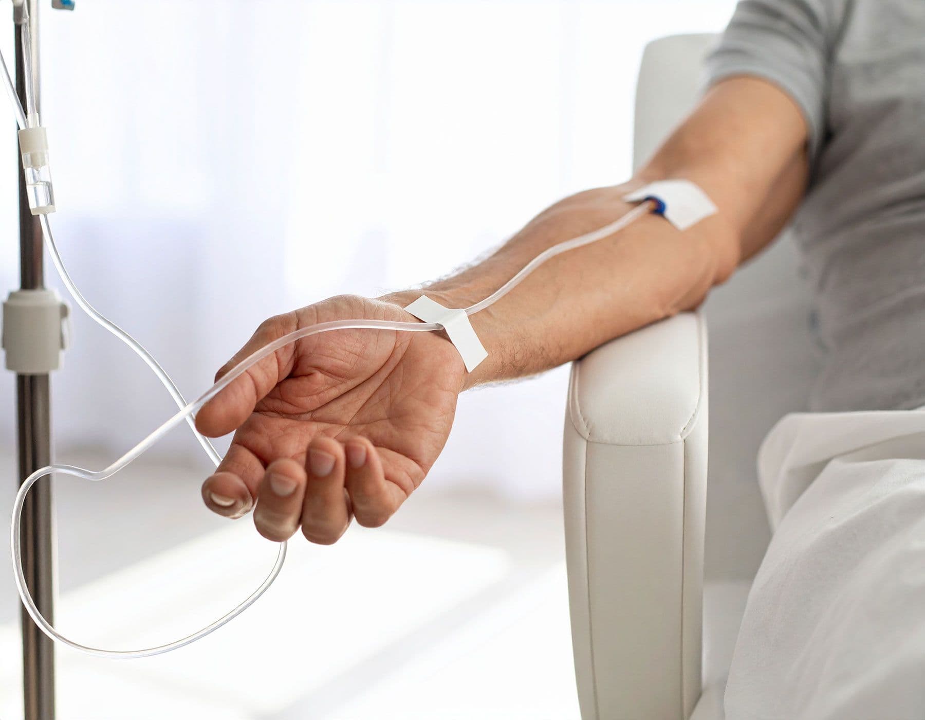 Arm eines älteren Mannes mit intravenösem Zugang zur Krebsbehandlung