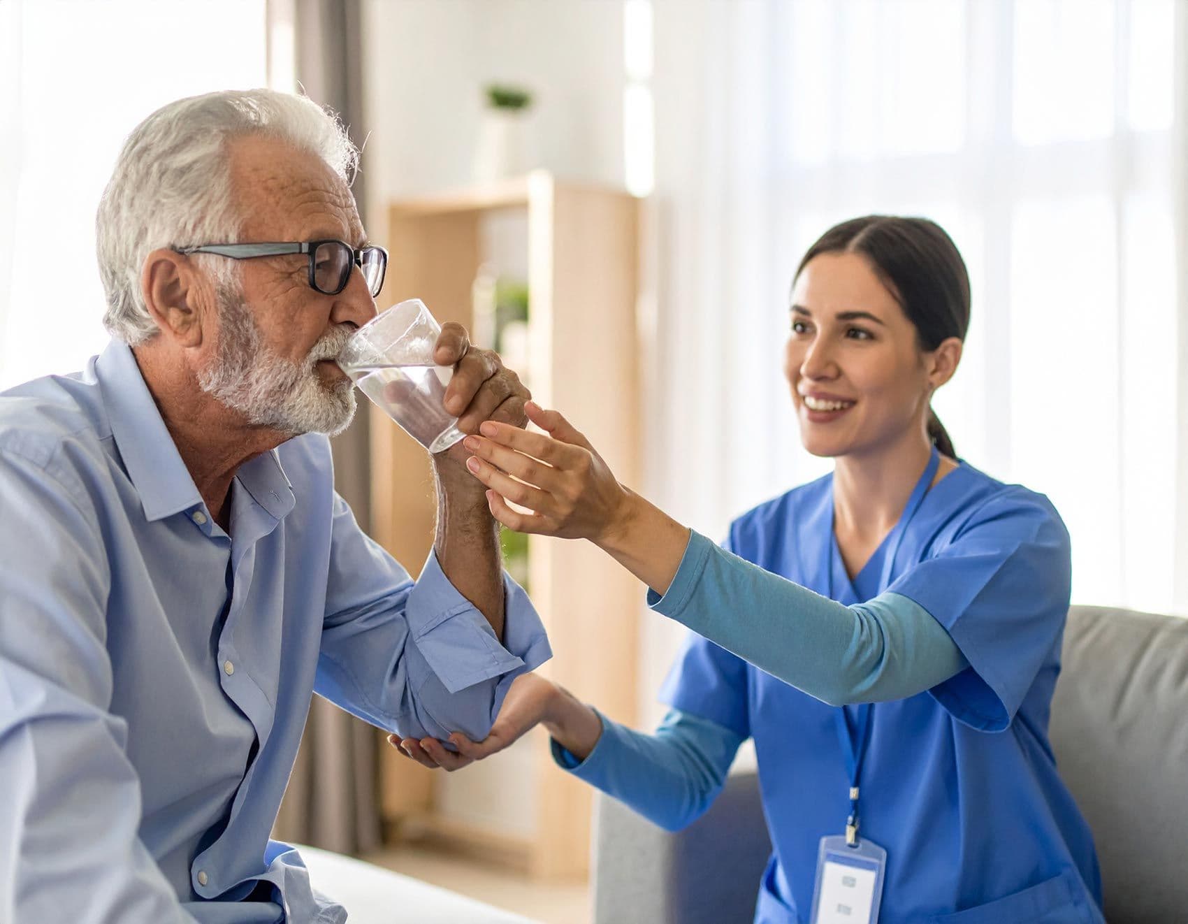 Pflegekraft in reicht einem älteren Mann mit Parkinson ein Glas Wasser