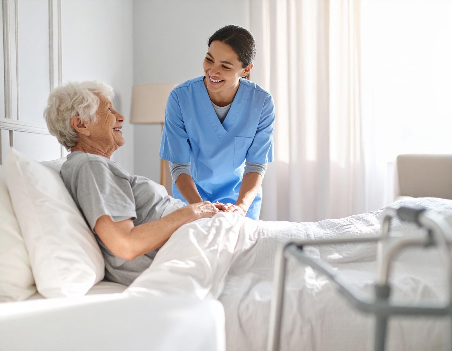 Pflegekraft betreut Seniorin im Bett