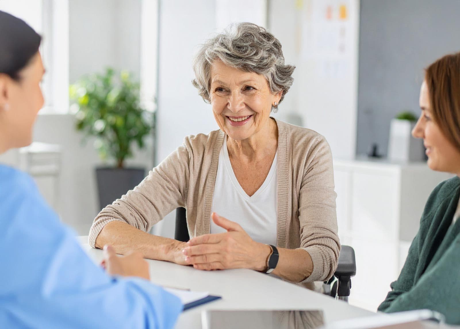 Ältere Frau spricht mit Sozialarbeiter bei Beratung am Tisch