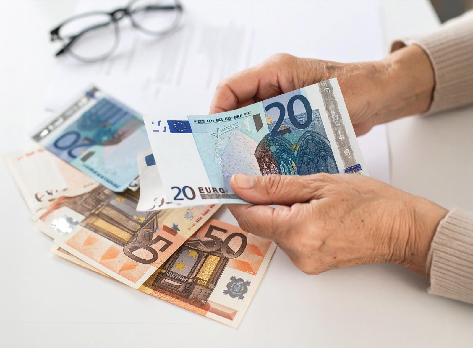 Ältere Person zählt Geld über einem Tisch